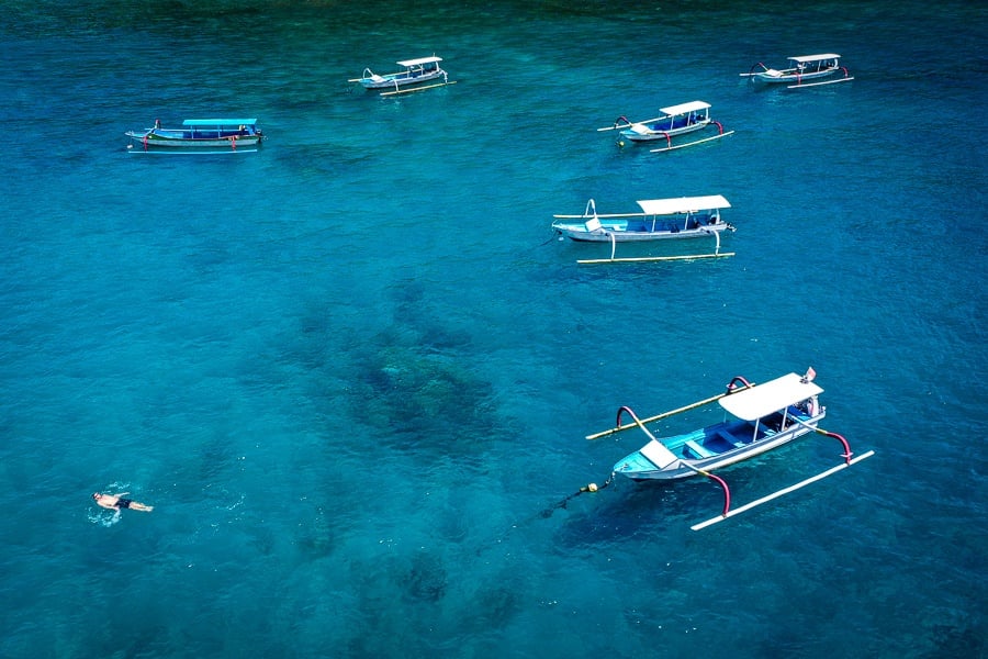 959.jpg" alt="Drone view of traditional jukung boats and swimmer floating at Crystal Bay in Nusa Penida Bali